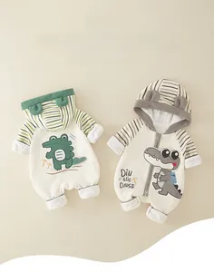 Detail view of cotton newborn jumpsuits with green crocodile and dinosaur cartoon embroidery