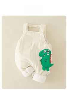 Détail de la barboteuse gaufrée pour bébé avec écusson dinosaure vert et boutons