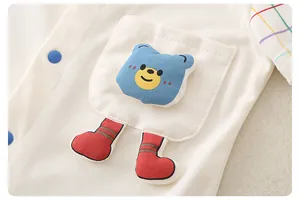 Detail of baby cotton romper with bear patch and colorful rainbow striped sleeve cuff