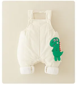 Détail de la barboteuse crème pour bébé avec texture gaufrée et écusson de dinosaure vert