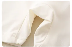 Detailed macro view of cream-colored pique cotton knit fabric for baby rompers