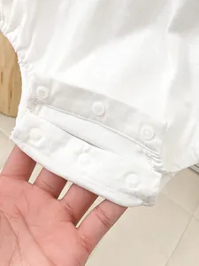 White cotton baby bodysuit with snap closure detail for easy diaper changing