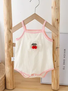 Cute baby girl cherry print romper with pink trim and lace details on wooden hanger