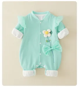 Detail of mint green waffle knit baby romper with 3D floral patches and ruffle shoulders