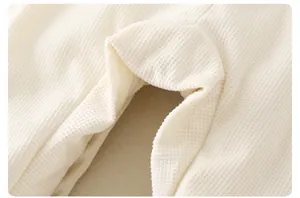 Détail de la texture gaufre douce et des coutures du pantalon pour bébé dinosaure