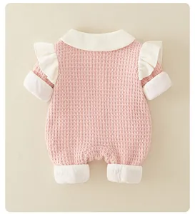Detail of pink baby romper showing waffle texture fabric and white Peter Pan collar