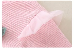 Detailed macro view of pink ribbed knit fabric with delicate soft tulle ruffle trim