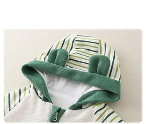 Detail of baby hooded romper showing green striped patterns and cute 3D ear design