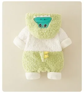 Détail d'une grenouillère bébé en polaire avec capuche dinosaure verte et tissu moelleux