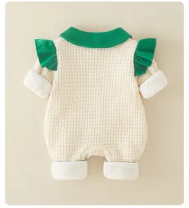 Detail of baby waffle knit romper featuring a green doll collar and ruffled shoulders