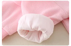 Detail shot of baby romper pink ribbed fabric sleeve with soft cotton lining texture