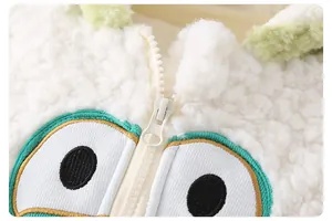 Détail du tissu sherpa doux avec broderie yeux de grenouille et fermeture éclair fluide