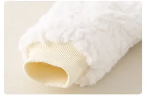 Gros plan d'un barboteuse bébé en sherpa blanc avec poignets côtelés beiges
