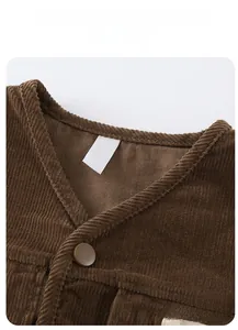 Detail view of the classic V-neckline and texture on the brown corduroy vest