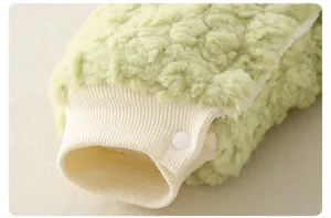 Gros plan d'une grenouillère bébé en polaire verte avec bord-côte et bouton pression