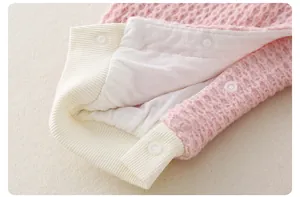 Detail of baby romper featuring waffle knit fabric and three secure white snap buttons