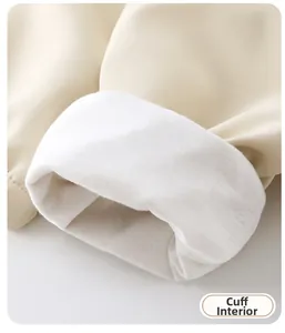 Close-up of soft white knitted cuff lining and smooth beige fabric on kids jacket