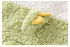 Vue détaillée du tissu polaire sherpa vert doux et du design d'oreille jaune mignon