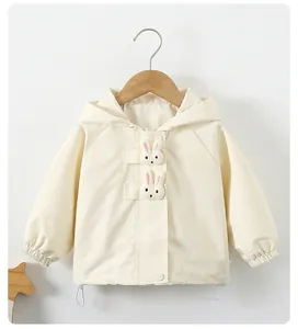 Detail of cream girls windbreaker featuring 3D rabbit decor and elastic cuffs