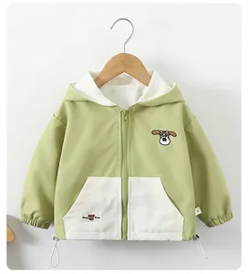 Detail of light green kids windbreaker jacket showing embroidery and adjustable hem cord
