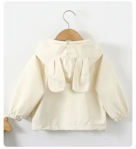 Detail of toddler hood with cute rabbit ears and drawstring hem on cream windbreaker
