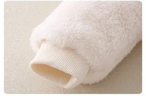 Vista macro dei polsini a costine e del morbido peluche della tutina invernale neonato