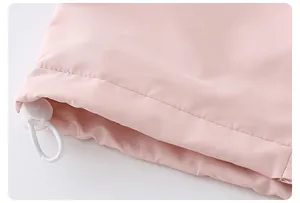 Detail of light pink waterproof fabric with adjustable elastic drawstring and round toggle