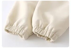 Close-up of beige jacket sleeve showing elastic ribbed cuff and durable fabric texture