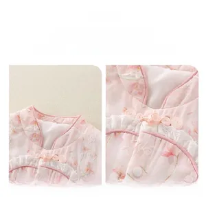 Détail de barboteuse bébé rose fleurie avec nœud chinois et bordure en dentelle