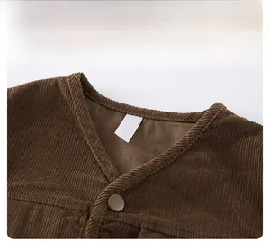 Detail view of brown corduroy vest featuring vertical rib texture and V-neckline finish