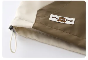 Detail of adjustable hem drawstring and cute bear tag on children windbreaker jacket
