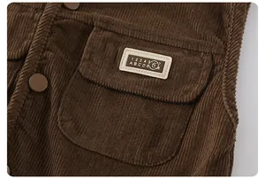 Macro view of brown corduroy vest featuring vintage numeric patch and textured fabric