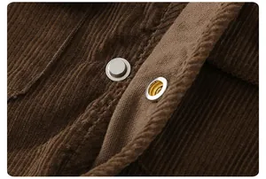 Detail view of silver metal snap buttons on premium brown corduroy fabric clothing