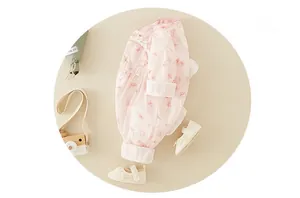 Détail d'une barboteuse à fleurs pour bébé avec manches longues et chaussures en dentelle