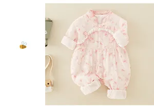 Détail de barboteuse bébé rose à fleurs avec boutons chinois et volants élégants