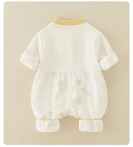 Detail of newborn baby romper featuring diamond knit texture and yellow floral patterns