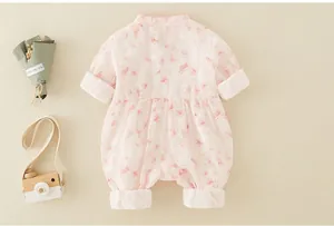 Détail d'un barboteuse bébé rose à fleurs avec col chinois et poignets en velours
