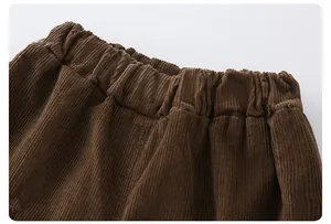 Close-up of elastic waistband and thick corduroy texture on dark brown boys' trousers