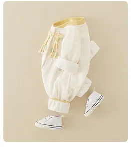 Detail of infant Chinese style romper with embroidery, knots and matching shoes