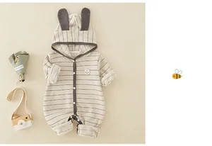 Detail of baby striped cotton romper with bunny ear hood and smiley face badge