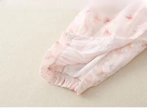 Détail d'une barboteuse bébé à fleurs avec volants et fermetures à boutons-pression