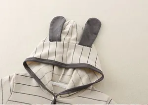 Detailed view of baby romper featuring grey bunny ears on a striped hooded knit cotton outfit