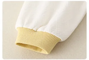 Detailed macro view of the baby romper quilted diamond texture and ribbed yellow cuff