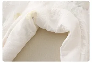 Macro detail of Chinese style floral jacquard fabric with delicate embroidery for baby rompers