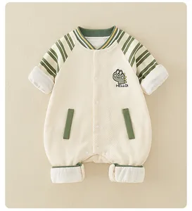 Detail of baby cotton romper featuring quilted fabric and green dinosaur embroidery