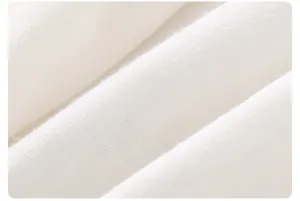 Close-up of soft white knitted cotton fabric with a fine texture on a baby romper