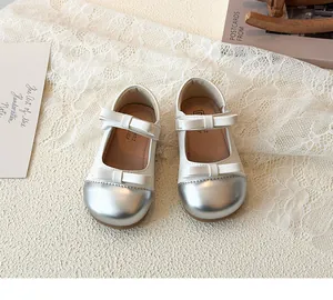 Detail of girls Mary Jane shoes with double bows and metallic silver toe design