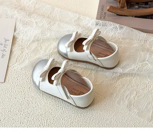Detail of cream Mary Jane shoes for girls with silver toe cap and double bow accents