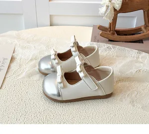 Detailed view of girls cream Mary Janes with silver toe cap and cute bows decoration