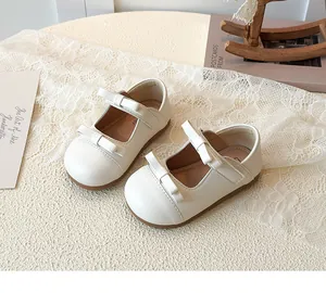 Detailed view of cream Mary Jane shoes with double bows and non-slip rubber soles